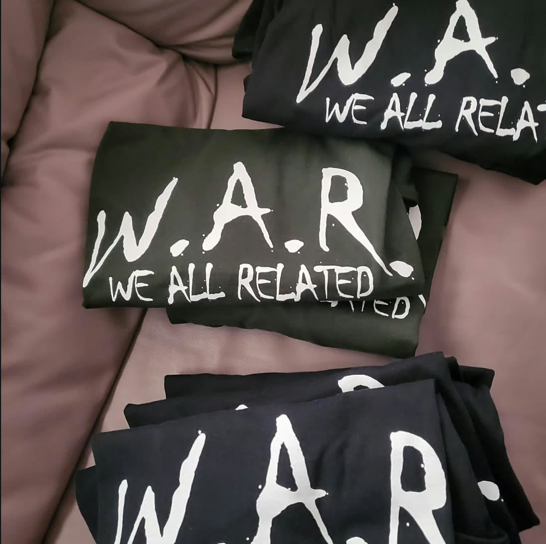 W.A.R. tee in black and olive colorways, folded flat